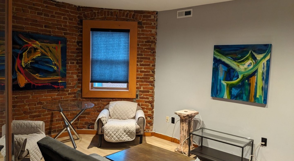 Live work space approximately 1500 sq ft, with hardwood floors, high ceilings and exposed brick wall
